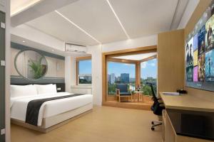 a bedroom with a bed and a desk and a television at JC Jinchen Lakeview Hotel in Gutang