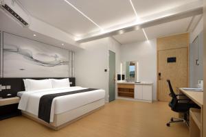a bedroom with a white bed and a desk and a desk at JC Jinchen Lakeview Hotel in Gutang