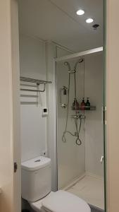 a bathroom with a toilet and a glass shower at JC Jinchen Lakeview Hotel in Gutang