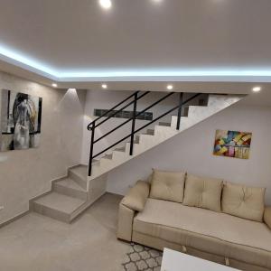 a living room with a couch and stairs at Apartman LUX Jelena in Surčin