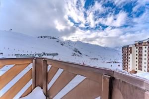 een uitzicht op een met sneeuw bedekte berg met een gebouw bij Cosy 5 persons / Ski In Ski out in Val Thorens
