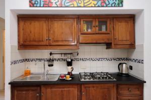 een keuken met houten kasten en een spoelbak bij Fidelio Holiday Home in Rome