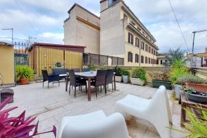 een terras met een tafel en stoelen en een gebouw bij Fidelio Holiday Home in Rome
