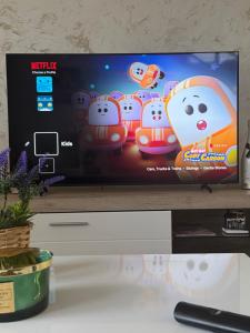 a flat screen tv sitting on top of a table at Apartman LUX Jelena in Surčin
