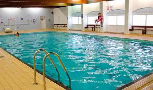 a swimming pool with blue water in a building at Gemini in Heysham