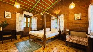 a bedroom with a bed and a table and a desk at Green Roots Farm Stay, Shahapur in Shāhāpur