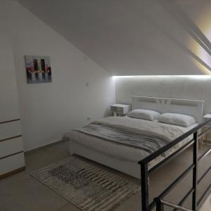 a bedroom with a bed in a white room at Apartman LUX Jelena in Surčin