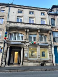an old building on a city street with windows at Le Cocon Commerçien in Commercy