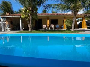 een huis met een blauw zwembad voor een huis bij Casa no cumbuco in Caucaia