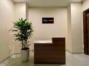 河内Collection O West Lake Apartment的接待台,在房间里放着盆子