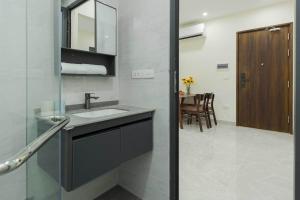 a bathroom with a sink and a mirror and a table at Collection O West Lake Apartment in Hanoi