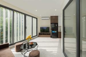 a living room with large windows and a table at Collection O West Lake Apartment in Hanoi