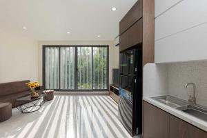 a kitchen with a large glass door to a living room at Collection O West Lake Apartment in Hanoi +62 photos