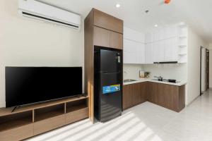 a kitchen with a black refrigerator and a tv at Collection O West Lake Apartment in Hanoi