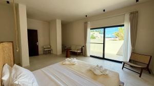 a bedroom with a large bed and a large window at Kano Boutique Hotel Paje in Paje