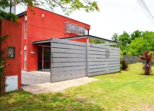 een rood huis met een garage en een rood bijgebouw bij Rumipaz in Villa Rumipal