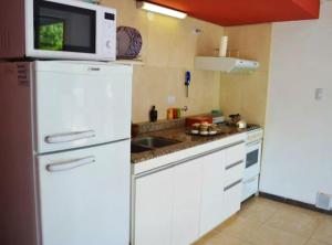 een keuken met een witte koelkast en een magnetron bij Rumipaz in Villa Rumipal