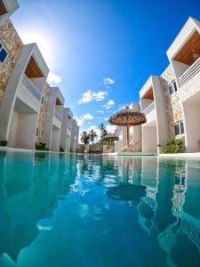 an infinity pool at a resort with an umbrella at MHV Milagres - Curimã B 1 in Passo de Camarajibe