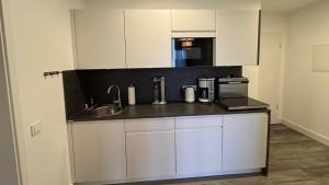een keuken met witte kasten en een spoelbak bij Ferienwohnung Passat in Olpenitzdorf in Olpenitzdorf