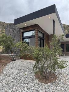 a house with a large window on the side of it at Ayres Lodge Vista Calma Potrerillos in Potrerillos