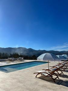 een zwembad met ligstoelen en parasols bij Finca La Mariquitaa in Murchas