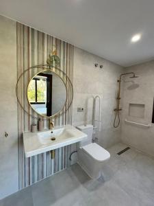 een badkamer met een wastafel, een toilet en een spiegel bij Finca La Mariquitaa in Murchas