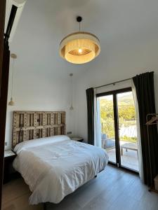 een slaapkamer met een bed en een groot raam bij Finca La Mariquitaa in Murchas