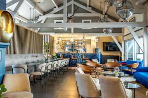 a restaurant with tables and chairs and a bar at Best Western Hotel Acadie Paris Nord Villepinte in Tremblay En France