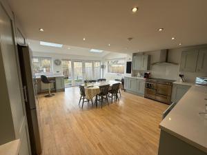 a large kitchen with a table and chairs in it at Oak View - Spacious 3 Bedroom House near Oxford and the Cotswolds in North Leigh