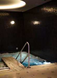 Un jacuzzi con una barandilla de metal en una habitación. en The Newman, en Londres