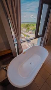 um lavatório branco numa casa de banho com uma janela em Hotel de Turistas Iquitos em Iquitos