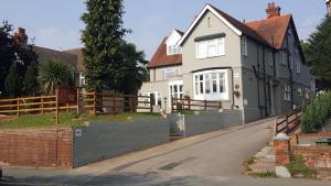 a house with a fence on the side of a road at Rye Court Hotel in High Wycombe