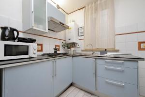 een keuken met witte kasten en een magnetron bij Fidelio Holiday Home in Rome