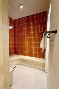 a bathroom with a shower with red tile at Kano Boutique Hotel Paje in Paje +21 photos