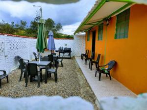 a group of tables and chairs with umbrellas on a building at Casa de Campo San Cayetano de los vientos in Tibasosa