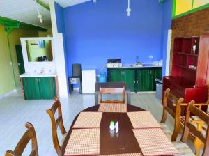 a room with a table and chairs and a blue wall at Casa de Campo San Cayetano de los vientos in Tibasosa