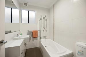 a white bathroom with a sink and a bath tub at Dune View in Lancelin +39 photos