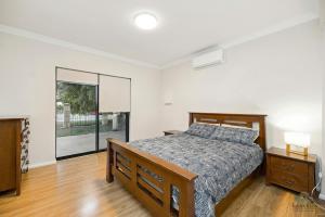 a bedroom with a bed and a large window at Dune View in Lancelin