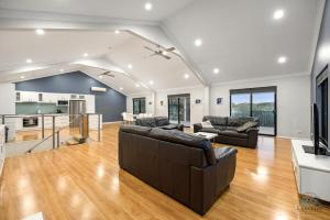 a living room with two couches and a kitchen at Dune View in Lancelin