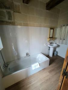 a bathroom with a white tub and a sink at Il figolla farmhouse private pool & sea view in Xagħra +110 photos