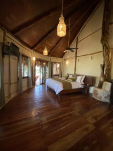 Un dormitorio con una cama y suelo de madera. en Villa Marcela, en Calderitas