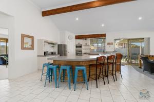 a kitchen with a large island with stools at White Sands in Lancelin