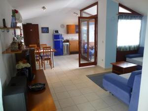 salon z niebieską kanapą i kuchnią w obiekcie Apartment Grozic w mieście Porat