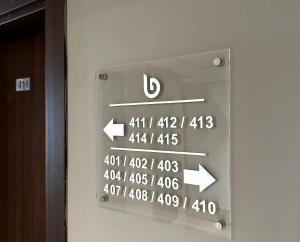 un cartello sul lato di una porta con delle frecce di Big Inn Luxury Hotel a Biga