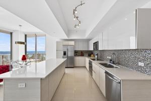a kitchen with white cabinets and a large counter top at Spacious VIP Penthouse with Ocean & Intracoastal Views, Private Entry, Resort Amenities in Hallandale Beach