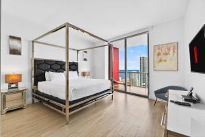 a bedroom with a canopy bed with a view of the ocean at Spacious VIP Penthouse with Ocean & Intracoastal Views, Private Entry, Resort Amenities in Hallandale Beach