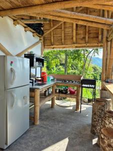 a kitchen with a white refrigerator and a table at Casa en las Nubes, Melgar Tolima in Melgar
