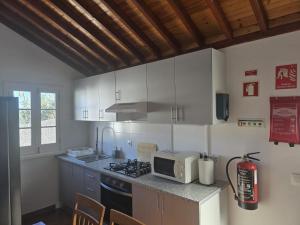 a kitchen with a microwave and a stove top oven at Recanto Vital in Achadinha