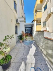 einen Gang zwischen zwei Gebäuden mit Topfpflanzen in der Unterkunft Villa Real Residential Area in Bombinhas