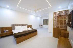 een slaapkamer met een bed en een televisie. bij Shivjanmabhumi Resort in Junnar